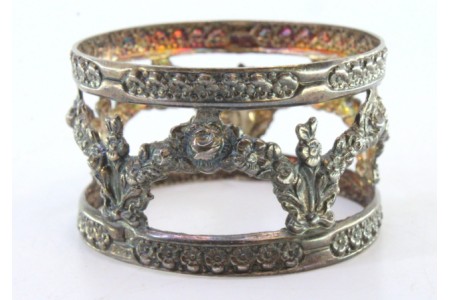 Argola de guardanapo em prata recortada com motivos florais e grinaldas suspensas.